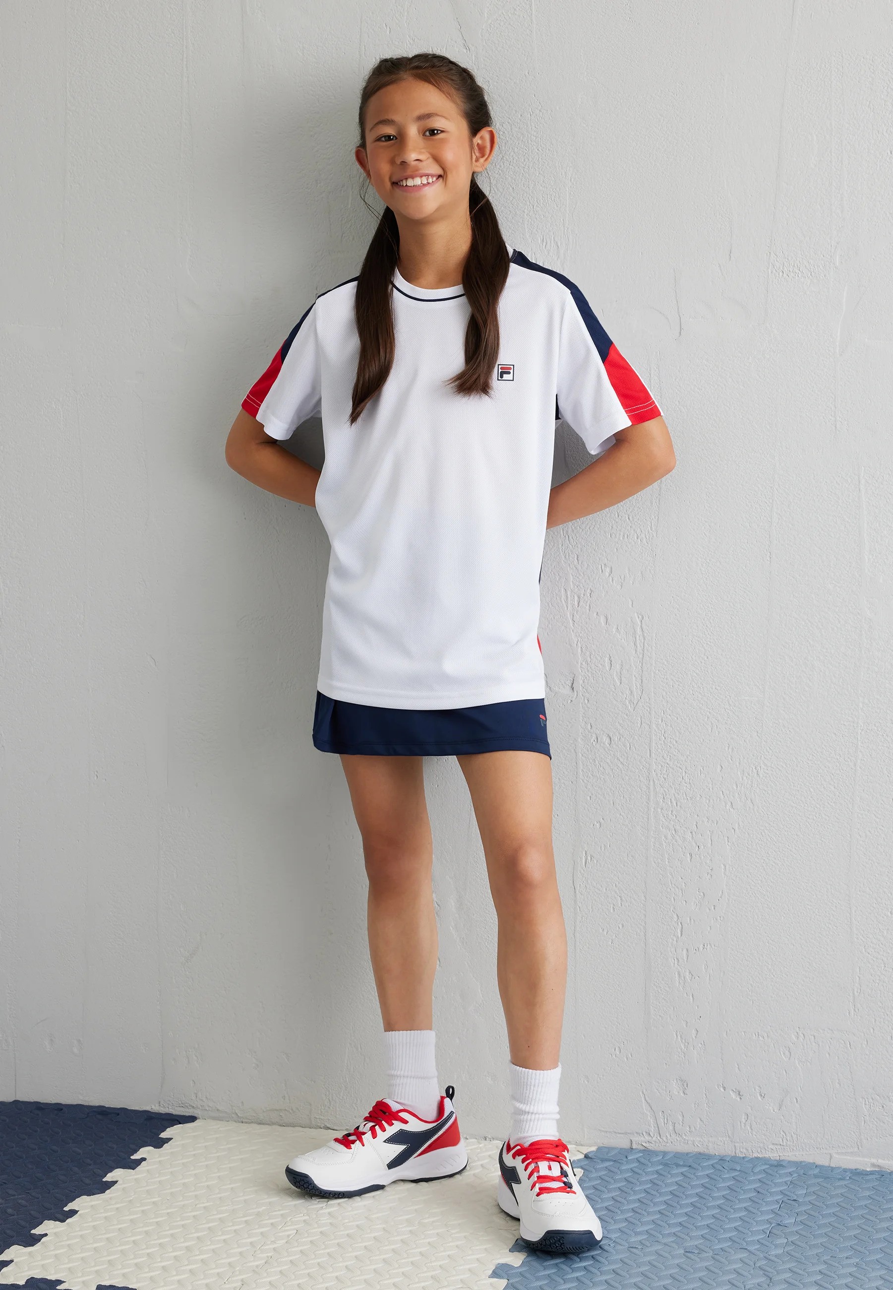 A lifestyle shot of a model wearing FILA apparel.